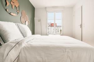 sypialnia z dużym białym łóżkiem i oknem w obiekcie Élégance Proche Disneyland w mieście Serris