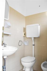 a bathroom with a toilet and a sink at Hotel Gialpina in Rimini