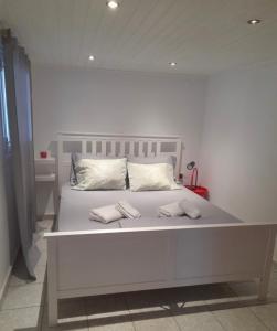 een wit bed met twee witte kussens erop bij Neochori Studio in Karpathos