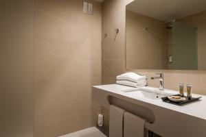 格拉諾列爾斯的住宿－奧古斯塔巴塞羅那瓦萊斯酒店，一间带水槽和镜子的浴室