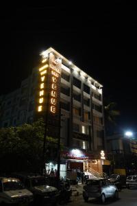HOTEL THE VENUE في دانباد: مبنى به لافته الفندق اضاءه بالليل