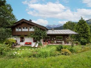 a house with a porch and a garden in front of it at Ferienhaus Riedlsperger in Fieberbrunn