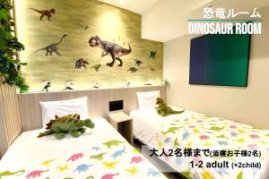 2 camas en una habitación con sala de dinosaurios y un mural en Henn na Hotel Sendai Kokubuncho, en Sendai