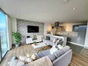 a living room with two couches and a tv at Pass the Keys Stunning Penthouse with Balcony Sunset Views in Belfast