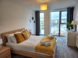 - une chambre avec un grand lit et une grande fenêtre dans l'établissement Pass the Keys Stunning Penthouse with Balcony Sunset Views, à Belfast