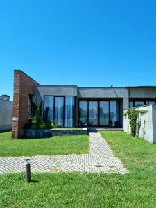 une grande maison avec des fenêtres en verre et une brique dans l'établissement Kakheti , Villa Ambassadori Kachreti Golf Resort, à Kachretʼi