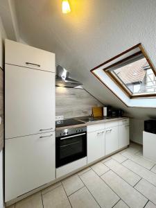 eine Küche mit weißen Schränken und einem Dachfenster in der Unterkunft 2-Zimmer im Herzen von Göttingen in Göttingen