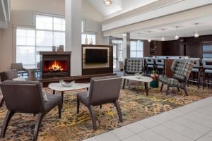 eine Lobby mit einem Kamin, Stühlen und einem Tisch in der Unterkunft Residence Inn by Marriott Houston Katy Mills in Katy