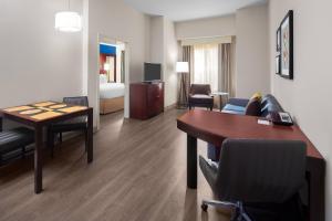 a hotel room with a desk and a living room at Residence Inn by Marriott Houston Katy Mills in Katy