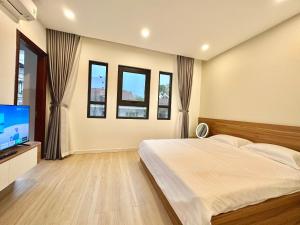 a bedroom with a bed and a flat screen tv at Pan House in Hanoi