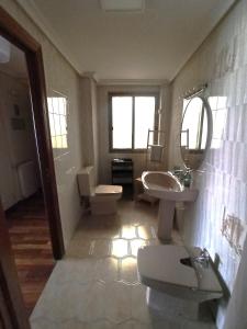 a bathroom with two sinks and a toilet and mirrors at LA BOTICA DEL MONASTERIO in Sahagún