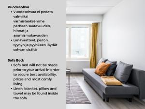 - un salon avec un canapé gris dans l'établissement Hiisi Homes Vantaa Keimolanmäki, à Vantaa