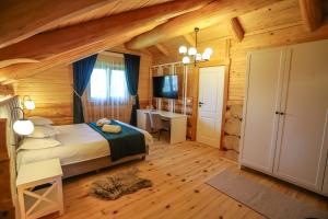 a bedroom with a bed and a desk at PENSIUNEA IZABELLA, Izabella Chalet in Topliţa