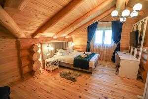 ein Schlafzimmer in einem Blockhaus mit einem Bett und einem Schreibtisch in der Unterkunft PENSIUNEA IZABELLA, Izabella Chalet in Topliţa