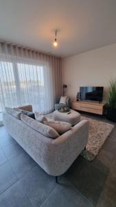 un soggiorno con divano e TV di Luxe 4p appartement aan jachthaven van Zeebrugge Met terrassen en gratis parkeren a Zeebrugge