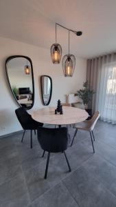 una sala da pranzo con tavolo, sedie e specchio di Luxe 4p appartement aan jachthaven van Zeebrugge Met terrassen en gratis parkeren a Zeebrugge