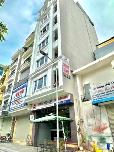 a large white building with an umbrella in front of it at Pan House in Hanoi