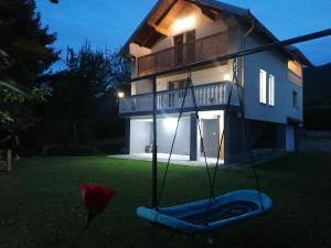 a house with a blue swing in the yard at Tranquil Retreat - "Villa Green Oasis" in Sarajevo