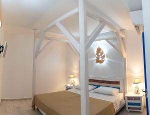 1 Schlafzimmer mit einem weißen Himmelbett und 2 Tischen in der Unterkunft I Catui dei Marinai in Diamante