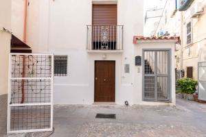 a white building with a wooden door on a street at I Catui dei Marinai in Diamante