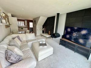 sala de estar con sofá blanco y TV grande en Fantastic 2-Bed House with Parking - Hosted by Hutch Lifestyle, en Leamington Spa