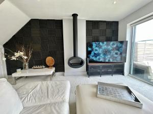 ein Wohnzimmer mit einem Sofa und einem Flachbild-TV in der Unterkunft Fantastic 2-Bed House with Parking - Hosted by Hutch Lifestyle in Leamington Spa