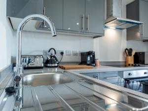 a kitchen with a sink and a counter top at Pass the Keys Stunning Apartment with Terrace in Telford
