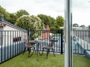 a table and two chairs on a balcony at Pass the Keys Stunning Apartment with Terrace in Telford