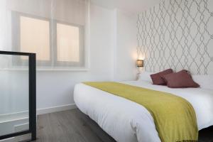 Ein Bett oder Betten in einem Zimmer der Unterkunft Suites Maestranza - Herrería by Magno Apartments