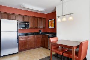 eine Küche mit einem weißen Kühlschrank und einem Tisch in der Unterkunft Residence Inn by Marriott Killeen in Killeen