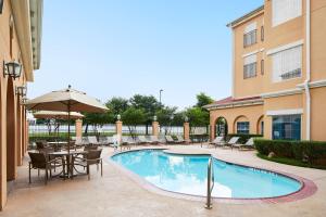 a swimming pool with chairs and a table and an umbrella at Residence Inn by Marriott Killeen in Killeen