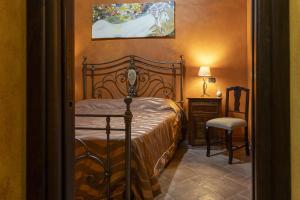 a bedroom with a bed and a table and a chair at Villino Il Melograno in Menfi