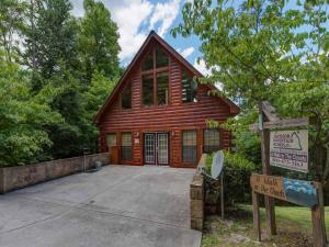 una casa de madera con un cartel delante en A Walk in the Clouds, 1 Bedroom, Sleeps 4, Pool Table, Hot Tub, Pets, en Gatlinburg