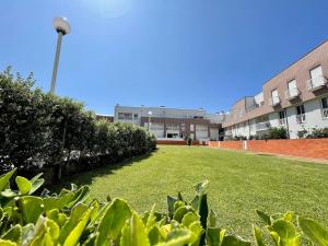 a large grassy yard in front of a building at Apartamento Ofir in Fão