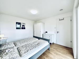 Dormitorio blanco con cama y armario en BUSINESS APARTMENT in Deitingen Tiny House ZIMMERzuVERMIETEN en Deitingen