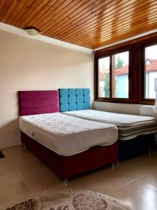 uma cama grande num quarto com duas janelas em Yalova Halic apartment em Yalova