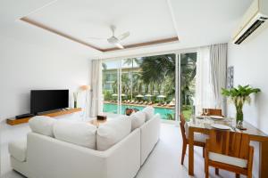 a living room with a white couch and a table at Chi Samui Resort in Bophut