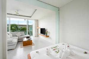 a living room with white furniture and a couch at Chi Samui Resort in Bophut