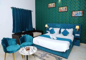 een hotelkamer met een bed en een stoel bij HOTEL MAYURA in Ajmer