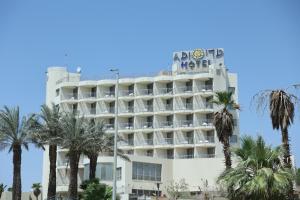 a hotel with a hotel sign on top of it at Adi Hotel in Eilat