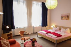 une chambre d'hôtel avec un lit et une chaise dans l'établissement Pension Siewert, à Dessau