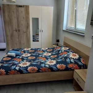 a bedroom with a bed with a blue and orange blanket at Majska Rosa in Resen