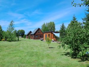 a house in the middle of a grassy field at Domek nad Szelągiem in Stare Jabłonki