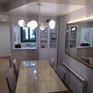 - une salle à manger avec une table en bois et un miroir dans l'établissement Dúplex en Valencia d'Àneu (Baqueira Beret), à Valencia de Aneu