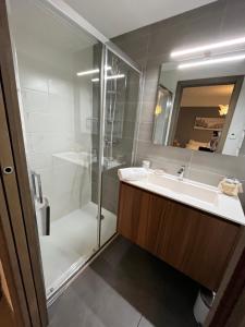 a bathroom with a shower and a sink and a mirror at Chalet Alpaga 3 classé 4 étoiles in Châtel