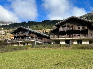 a large building with a grass field in front of it at Chalet Alpaga 3 classé 4 étoiles in Châtel