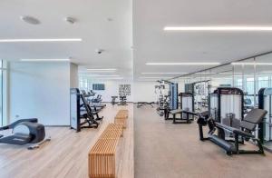 a gym with several treadmills and machines in it at Exquisite 2BR in Sunrise bay at Emaar Beachfront in Dubai