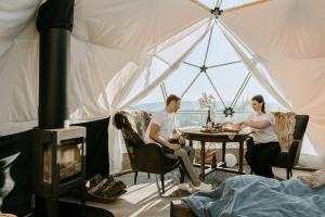 Un uomo e una donna seduti a un tavolo in una tenda di Arctic Dome Namdalen a Hoylandet