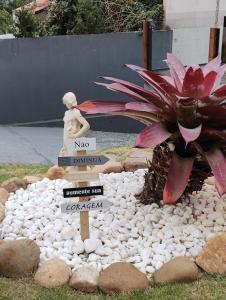 a garden with a statue and a flower and rocks at Hostel SIL CARDOSO in Blumenau