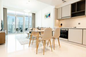 a kitchen and dining room with a table and chairs at Exquisite 2BR in Sunrise bay at Emaar Beachfront in Dubai